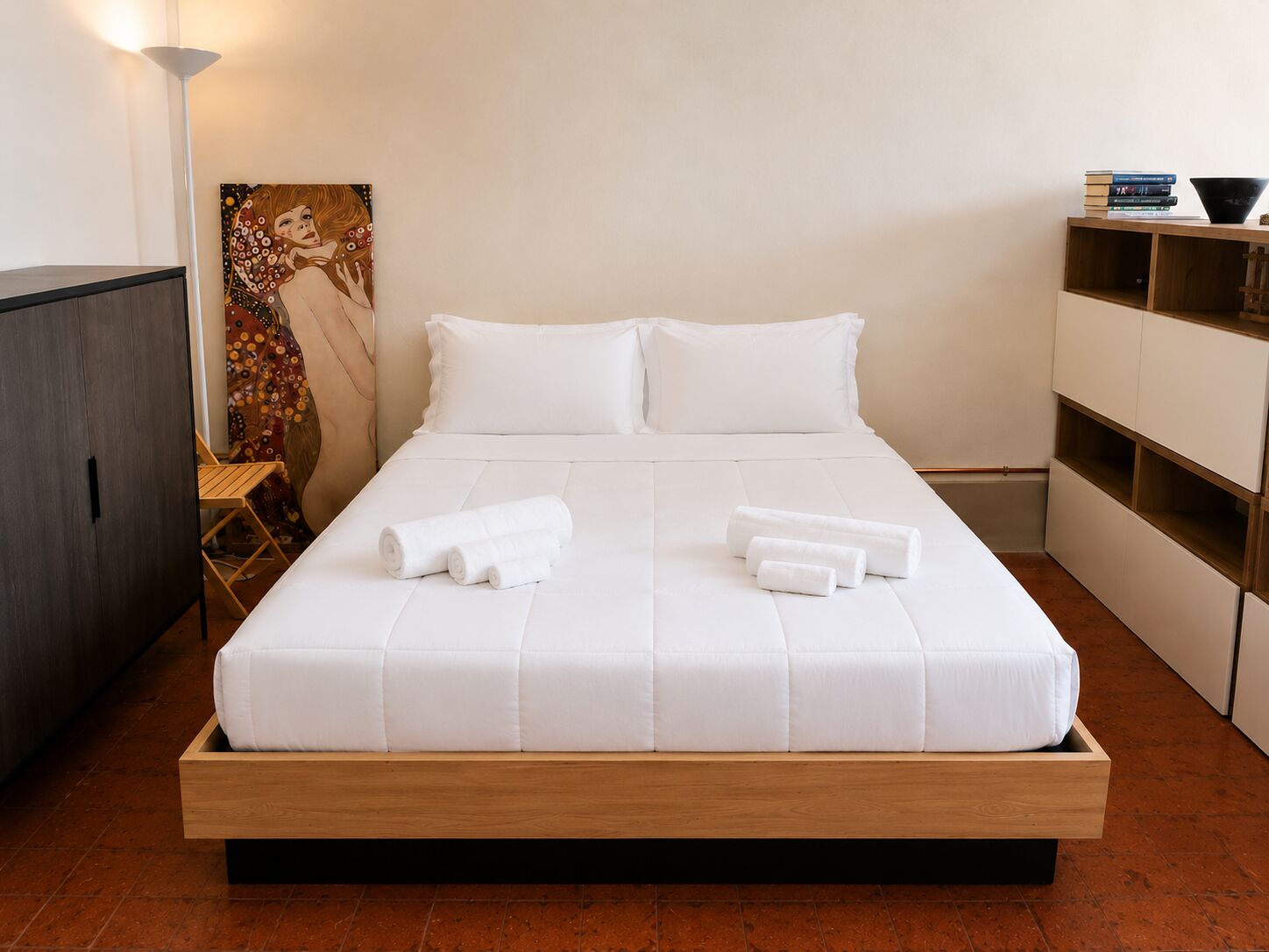 La camera da letto con letto matrimoniale in legno e quadro decorativo