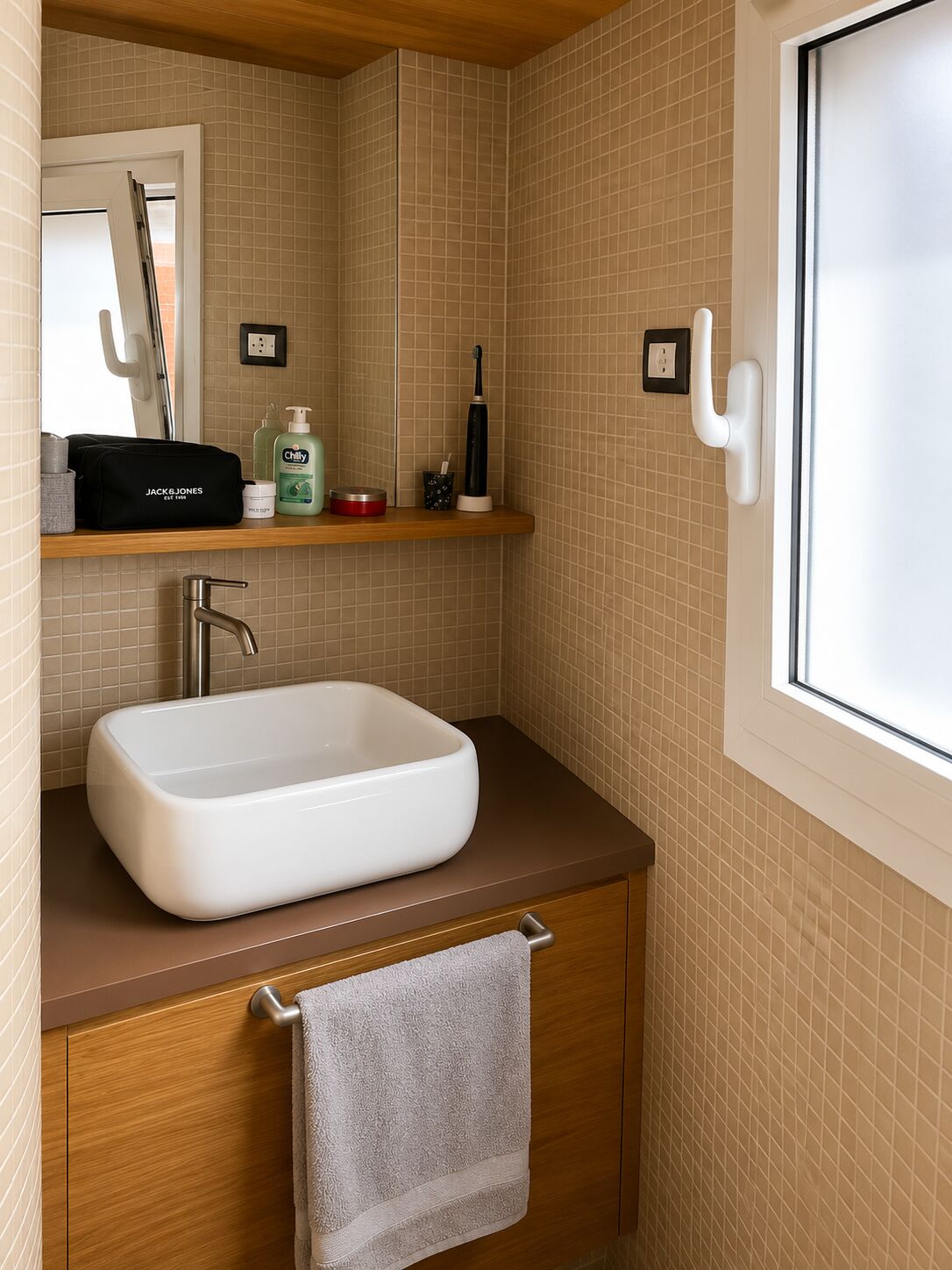 Il lavabo del bagno in ceramica bianca su mobile in legno